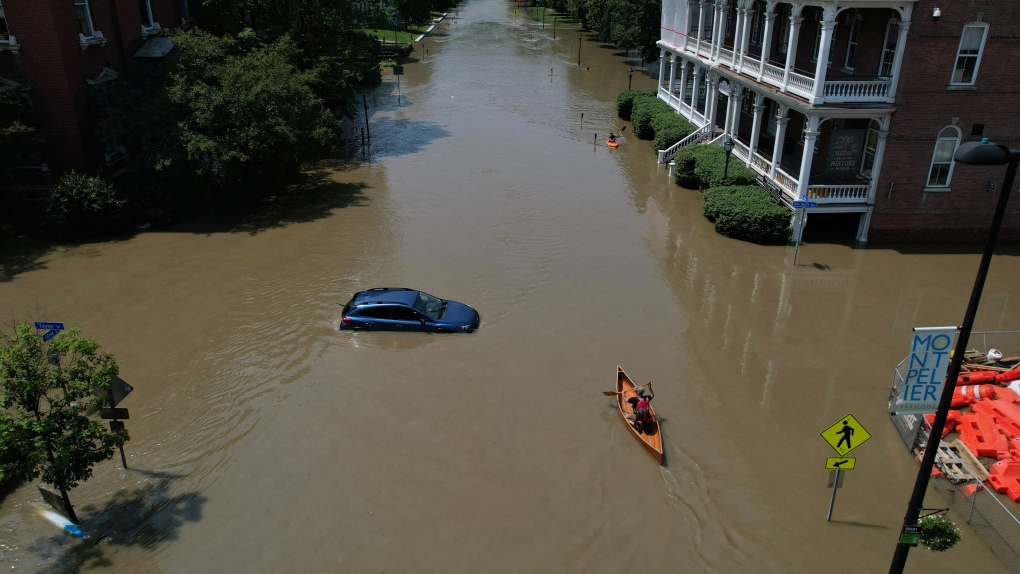 A person paddles a canoe down a street flooded by extreme rain in Montpelier, Vermont, on July 11. Brian Snyder/Reuters