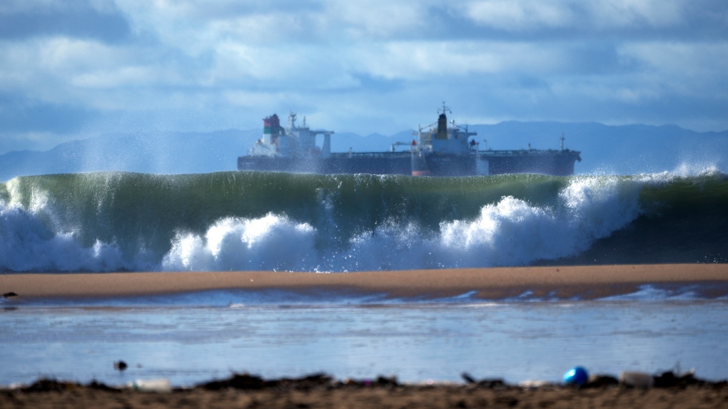 Giant waves break off the beach as shipping vessels remained moored along the coast of Southern California, seen from Seal Beach, Calif., Saturday, Dec. 30, 2023. (AP Photo/Damian Dovarganes)