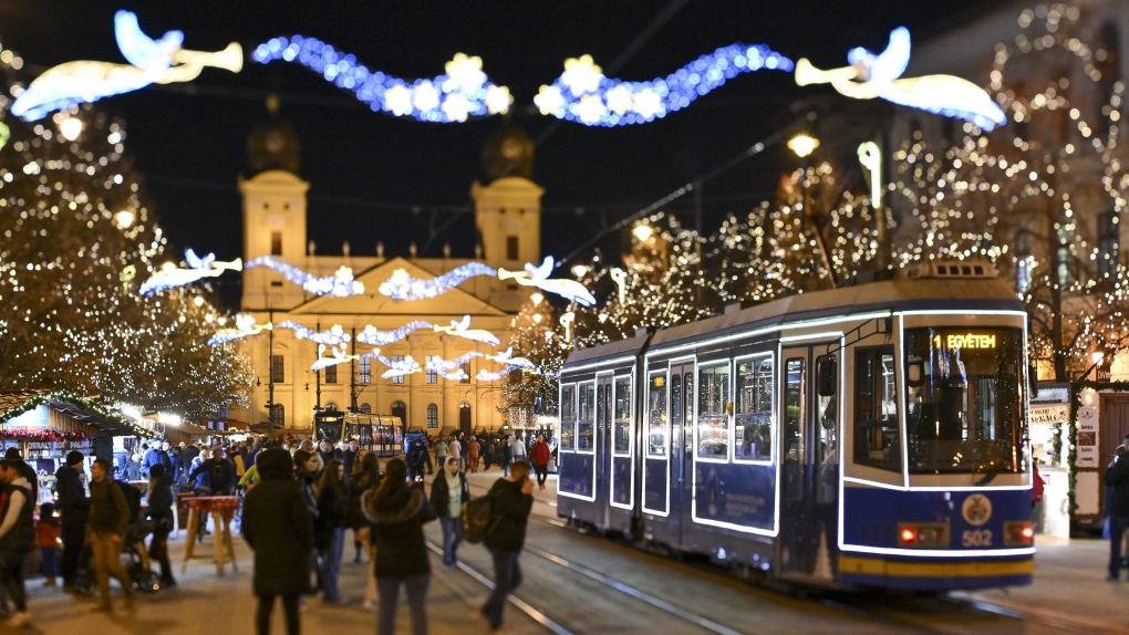 A tram illuminated with Christmas lights commutes in the city centre of Debrecen, northeastern Hungary, Tuesday, Dec. 12, 2023. (Zsolt Czegledi/MTI via AP)