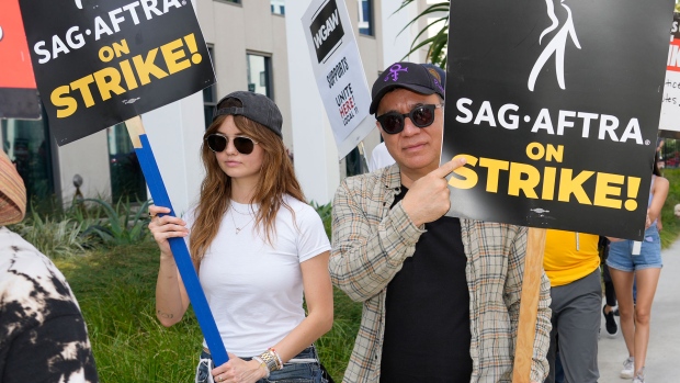 Debby Ryan, left, and Fred Armisen walk on a picket line outside Netflix studios on Friday, July 21, 2023, in Los Angeles. (AP Photo/Chris Pizzello)
