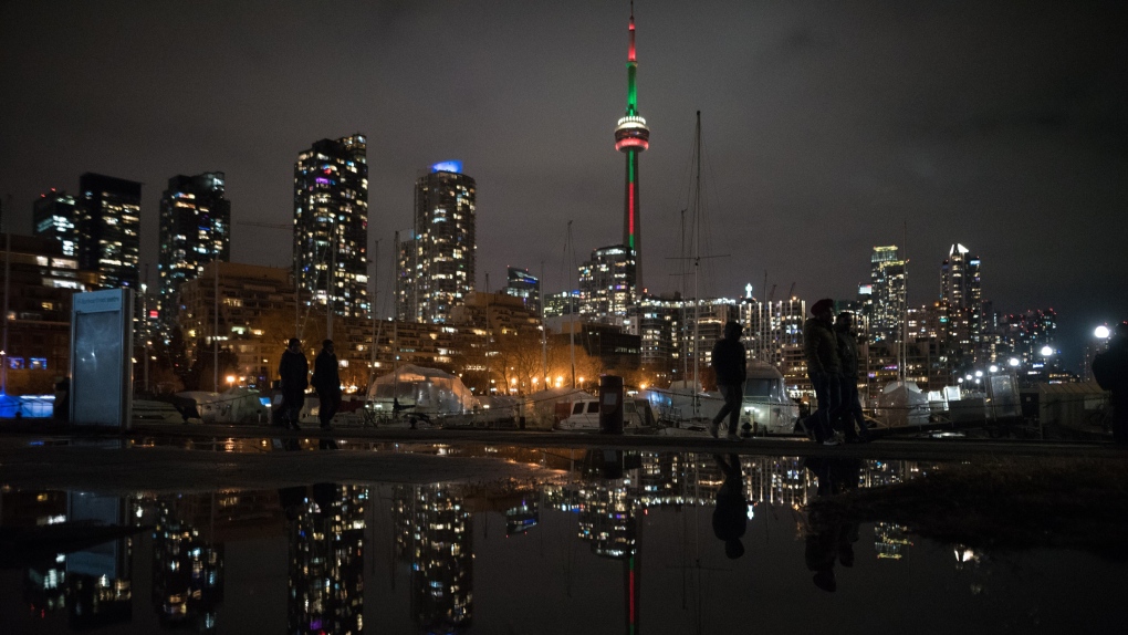 People make their way along the lakeshore ahead of the New Year's fireworks display over Toronto's inner harbour, Saturday, Dec. 31, 2022. THE CANADIAN PRESS/ Tijana Martin