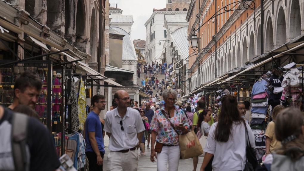 Tourists walk in a crowded street in Venice, Italy, Wednesday, Sept. 13, 2023. Venice on Saturday, Dec. 30, 2023 announced new limits on the size of tourist groups in another measure aimed at reducing the pressure of mass tourism on the famed canal city. Starting in June, groups will be limited to 25 people. (AP Photo/Luca Bruno, File)